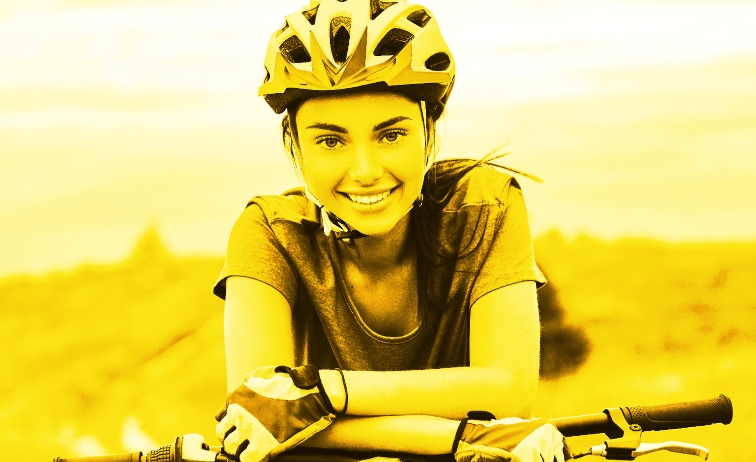 Young girl with bicycle helmet and gloves leaning on bike