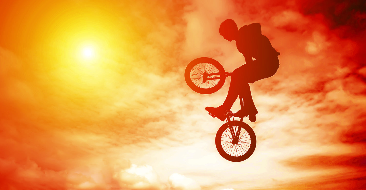 Silhouette of boy on a BMX bike against a sunset background - Apple County Cycles, 11B Westpark, Wellington, Somerset